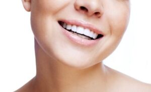 A young woman smiling after an anxiety-free visit to the dentist.