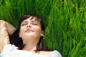 A girl sleeping on grass without concern about sleep apnea.
